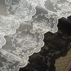 Peut inclure: Un tissu en dentelle blanche transparente pr&eacute;sentant un motif r&eacute;p&eacute;titif de ch&acirc;teaux brod&eacute;s entour&eacute;s de bordures florales festonn&eacute;es. Le mat&eacute;riau en maille d&eacute;licate affiche un travail de fil blanc complexe, tandis qu'une version noire du m&ecirc;me motif de dentelle est visible sous la couche blanche.