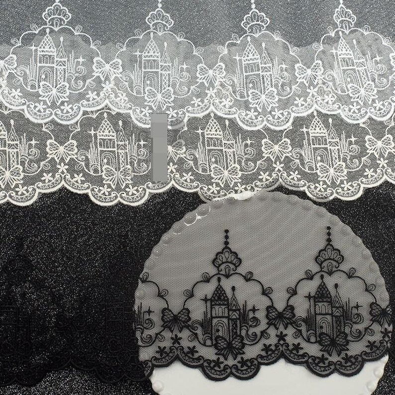 Peut inclure: Une bordure en dentelle blanche et noire pr&eacute;sentant un motif r&eacute;p&eacute;titif de silhouettes de ch&acirc;teaux dans des arches festonn&eacute;es, agr&eacute;ment&eacute; de petits n&oelig;uds et d'&eacute;toiles. La broderie complexe est sur un tissu en maille transparente festonn&eacute;.