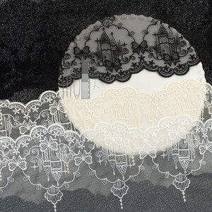 Peut inclure: Une bande de dentelle d&eacute;corative pr&eacute;sentant un motif r&eacute;p&eacute;titif de silhouettes de ch&acirc;teaux, de papillons et d'&eacute;toiles. La bordure est disponible en noir, blanc et cr&egrave;me, avec un bord festonn&eacute; et une base en maille fine, avec une &eacute;chelle de gris.