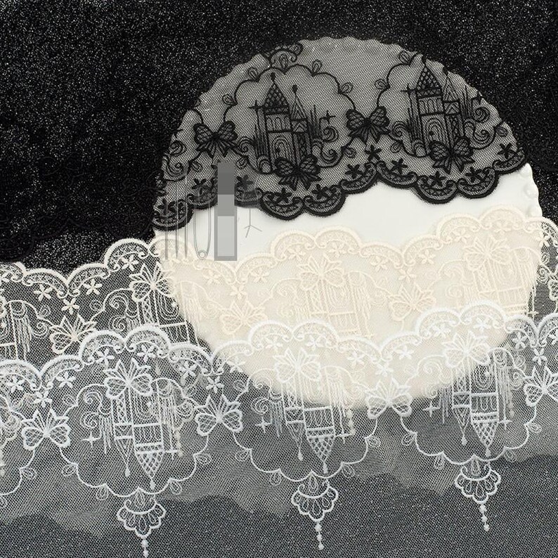 Peut inclure: Une bande de dentelle d&eacute;corative pr&eacute;sentant un motif r&eacute;p&eacute;titif de silhouettes de ch&acirc;teaux, de papillons et d'&eacute;toiles. La dentelle est disponible en noir, blanc et cr&egrave;me, avec un bord festonn&eacute; et des broderies complexes sur tout le tissu.