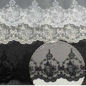 Peut inclure: Une bordure en dentelle blanche et noire pr&eacute;sentant un motif r&eacute;p&eacute;titif de silhouettes de ch&acirc;teaux, d'&eacute;toiles et de n&oelig;uds. La broderie complexe est sur un fond en maille transparente avec un bord festonn&eacute;, r&eacute;v&eacute;lant un design architectural.