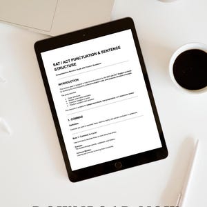 May include: A black tablet displays a study guide titled "SAT / ACT Punctuation & Sentence Structure." The guide includes sections on commas and other grammar rules. A laptop, coffee cup, pen, and decorative item are also visible on the white surface.