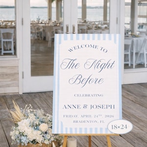 May include: A wedding welcome sign with the text "Welcome to The Night Before Celebrating Anne & Joseph Friday, April 24th, 2026 Bradenton, FL." The sign is 45.7x61 cm and is on a wooden easel. A basket of flowers and candles are in front.