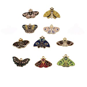 Puede incluir: Una colección de diez colgantes de mariposas nocturnas de colores con lazos dorados para hacer joyas. Los colgantes presentan diseños intrincados en varios colores, incluyendo negro, rosa, amarillo, azul y verde. Cada colgante mide aproximadamente 2,5 cm de ancho.