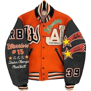 May include: Orange and black varsity jacket with the word "Warriors" and the number "15" on the left sleeve. The right sleeve has "39" and "1974 Champions" and "1975 Champions". The jacket has a white, black, and orange striped collar.