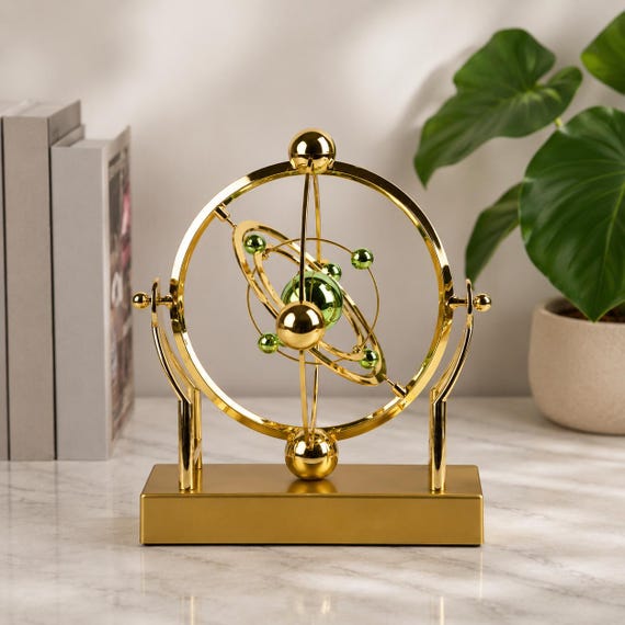 A rotating celestial orbit pendulum desk sculpture — part astronomy model, part hypnotic kinetic art, the kind of thing that makes visitors stop and stare.