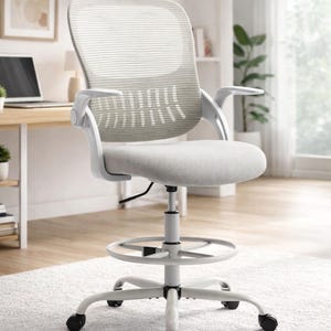 May include: A white and gray ergonomic office chair with a mesh back and adjustable armrests. The chair has a footrest and a five-wheel base for stability. The seat and back are upholstered in a light gray fabric.