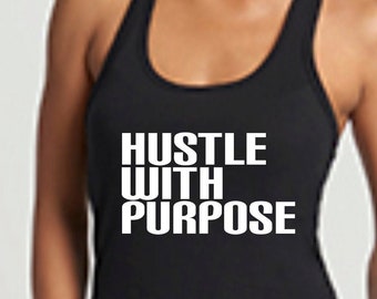 Könnte beinhalten: Ein schwarzes Tanktop mit dem weißen Text "HUSTLE WITH PURPOSE". Die Person trägt eine blaue Jeans.