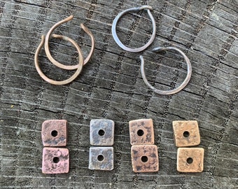 May include: A set of four pairs of earrings in silver, copper, and brass. The earrings are in the shape of hoops and squares.