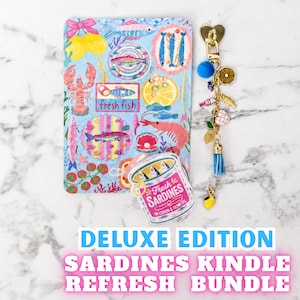 May include: A rectangular sticker sheet featuring colorful illustrations of fish, shrimp, lobster, and lemons with the text fresh fish, a sardine tin shaped sticker labeled Fresh SARDINES IN LEMON & OLIVE OIL, and a gold-toned keychain with charms.