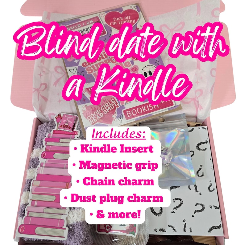 May include: A pink box labeled "Blind date with a Kindle" contains a Kindle insert, magnetic grip, chain charm, dust plug charm, and more. The box includes stickers and a stack of pink book-shaped items. The text "GOOD GIRLS READ SMUT" is visible.