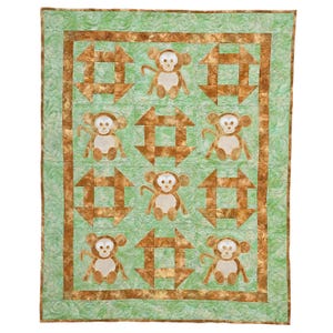 May include: A handmade quilt featuring a repeating pattern of brown and tan monkey appliqués and geometric shapes on a light green background. The quilt has a brown border and a quilted texture.