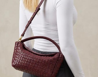 Bolso de hombro de piel trenzada con cierre de solapa plegable.