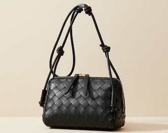 Bolso bandolera de piel auténtica tejida en negro, con correa de nudo trenzado.