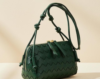 Bolso bandolera de piel auténtica tejida en verde oscuro, con correa de nudo trenzado.