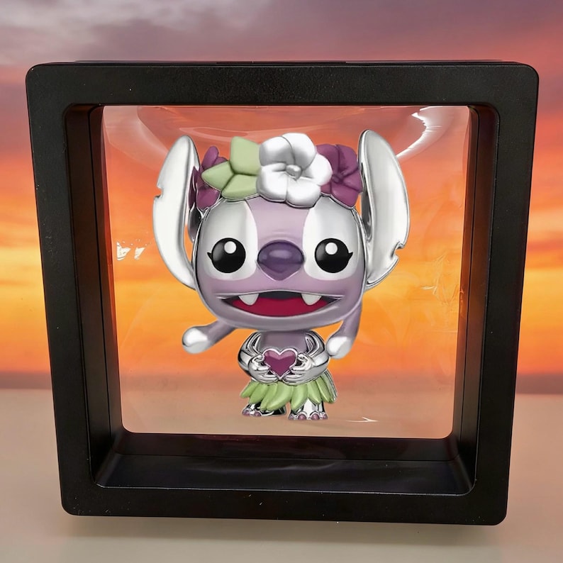May include: A metallic purple character figurine with large ears, wearing a floral crown of white, green, and purple flowers and a green skirt, holding a small purple heart. The figure is suspended inside a square black floating display frame.