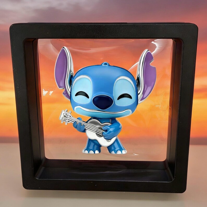 Puede incluir: Una figura de personaje azul con orejas grandes y detalles interiores morados, sosteniendo un peque&ntilde;o ukelele blanco. La figura est&aacute; encerrada dentro de un marco de exhibici&oacute;n flotante negro cuadrado con una membrana transparente y flexible.