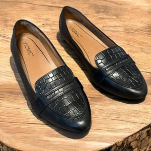 May include: A set of three ceramic mugs with a speckled, matte finish. The mugs are in shades of cream, light gray, and dark gray. Each mug has a simple, minimalist design and a rounded handle.