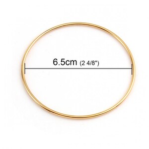 May include: A gold-colored metal bangle bracelet with a diameter of 6.5 cm (2 4/8 inches).