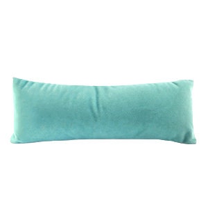 May include: A long, rectangular turquoise blue velvet pillow.