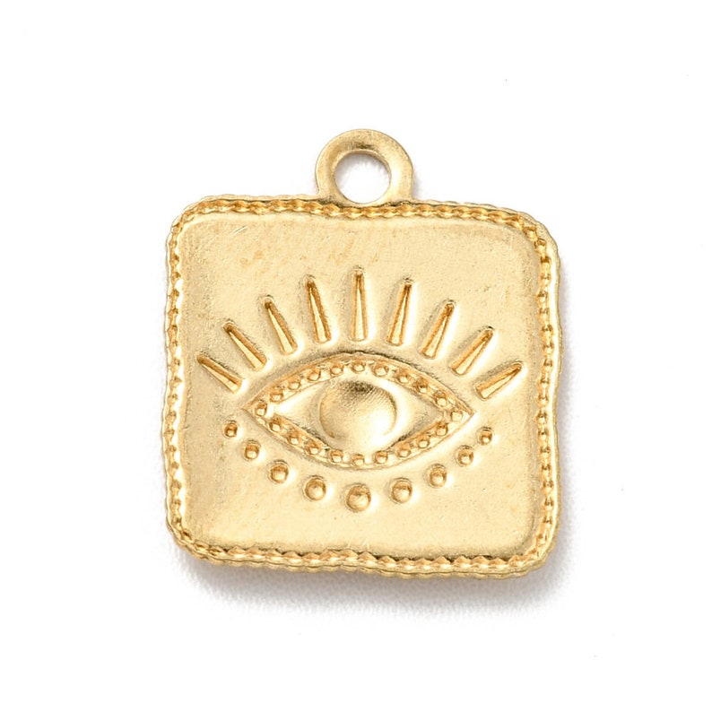 K&ouml;nnte beinhalten: Goldener quadratischer Anh&auml;nger mit einem gepr&auml;gten b&ouml;sen Auge. Das Auge hat einen Kreis aus kleinen Punkten und ein Sonnenstrahlen-Design dar&uuml;ber.