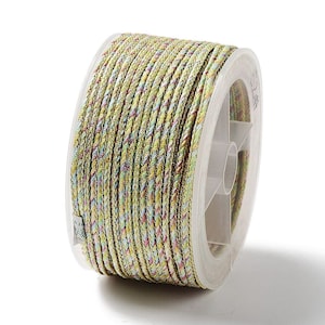 May include: A spool of multi-colored braided cord. The cord is primarily a light green color with interwoven strands of yellow, pink, and blue. The cord is tightly wound on a clear plastic spool, suitable for crafts and jewelry making.