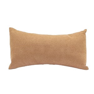 May include: A long, rectangular, light brown throw pillow with a soft, fuzzy texture.