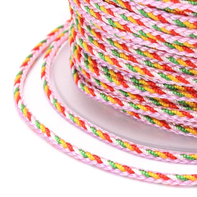 May include: A spool of pink, green, yellow, and red braided cord.