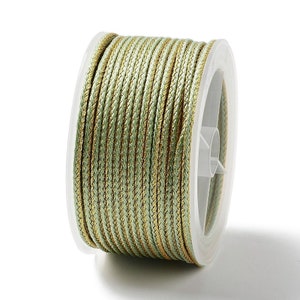 May include: A spool of green and gold cord, perfect for crafting and decorating.