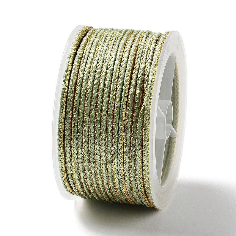 May include: A spool of green and gold cord, perfect for crafting and decorating.
