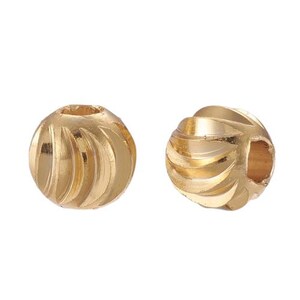 Op de afbeelding: Twee gouden metalen kralen met een swirl-ontwerp. De kralen hebben een gat in het midden om te rijgen.