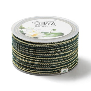 May include: A spool of green and gold striped cord labeled "Jewellery cord" with the Chinese characters "龍 騰" on the label.