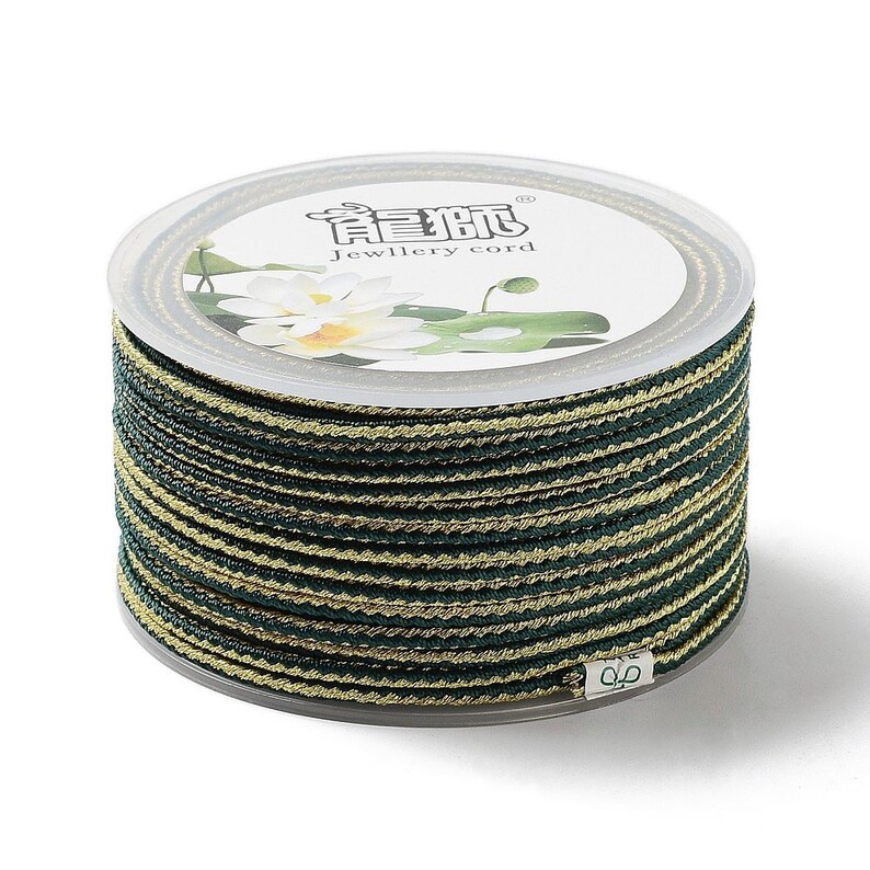 May include: A spool of green and gold striped cord labeled "Jewellery cord" with the Chinese characters "龍 騰" on the label.