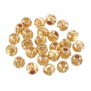 K&ouml;nnte beinhalten: Eine Sammlung von 20 goldfarbenen Metallperlen mit einem geriffelten Design. Die Perlen sind rund und haben ein Loch in der Mitte zum Auf f&auml;deln.