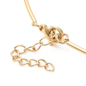 May include: Gold-toned necklace with a delicate chain and a lobster clasp closure.