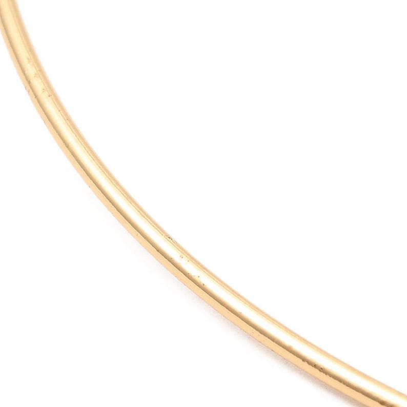 May include: A simple gold bangle bracelet. The bracelet is made of a single, thin band of gold.