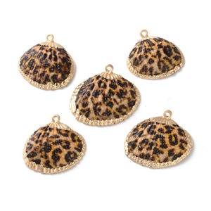 May include: Five gold-toned shell charms with a leopard print design. The shells are about 1.5 inches in diameter.