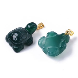 May include: Two green jade turtle pendants with gold-tone bail. The turtles are carved in a detailed, realistic style.