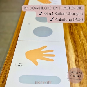 May include: White printed cards with orange hand illustrations, gray circles, and text. The cards include the text "IM DOWNLOAD ENTHALTEN SIE: 34 a4 Seiten &Uuml;bungen ✓ Anleitung (PDF)" and "Digitales PRODUKT PDF Download".
