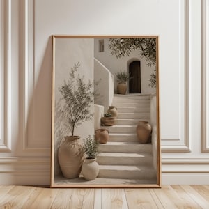 Könnte beinhalten: Ein gerahmter Wandkunstdruck, der eine Steintreppe zeigt, die zu einer dunklen Bogentür führt. Mehrere terrakottafarbene Keramiktöpfe und Vasen unterschiedlicher Größe stehen auf den Stufen und dem Treppenabsatz und enthalten grüne Olivenzweige.