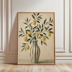 May include: A framed wall art print featuring a painting of a striped vase with green and white vertical lines. The vase holds a leafy branch with several yellow lemons. The background of the artwork is a solid, light beige color.