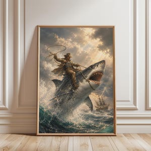 Puede incluir: Una impresión de arte mural enmarcada que muestra a una persona con abrigo y sombrero color canela montando un gran tiburón a través de olas turbulentas. El tiburón salta del agua con la boca abierta y un velero se ve al fondo.