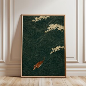 Puede incluir: Una lámina de arte mural vertical enmarcada con un fondo verde oscuro, líneas doradas finas y fluidas que representan corrientes de agua y crestas de olas estilizadas de color crema. Un tigre naranja y negro nada en la parte inferior izquierda.