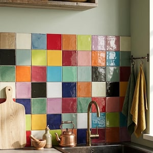 May include: A colorful kitchen backsplash composed of square tiles in various colors, including red, blue, yellow, and green. A copper kettle and faucet are visible, along with a wooden cutting board and a sink. The text "Hội An, 2024" is at the bottom.
