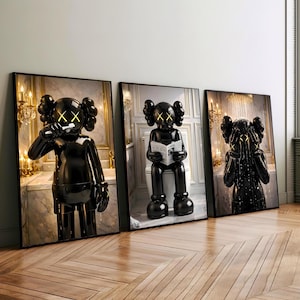 Peut inclure: Ensemble de trois impressions d'art encadrées représentant des sculptures noires brillantes avec des yeux 'XX' jaunes. L'une se brosse les dents, une autre lit un journal et la troisième se couvre le visage. Les fonds montrent des salles de bains luxueuses.