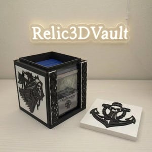 May include: A black and white 3D printed deck box for trading cards featuring a skull and ship design on the side and a removable lid with an anchor and skull emblem. The box displays a Swamp card and the text Relic3DVault is visible above.