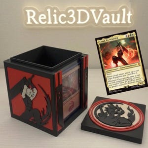 May include: A black and red square trading card deck box featuring a relief of a spiky-haired character wielding a large sword. The lid displays a circular emblem of the same character. A Cloud, Ex-Soldier Magic: The Gathering card is shown.