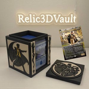 May include: A black and cream-colored square deck box featuring a silhouette of a character on the side and a matching circular emblem on the lid. A Magic: The Gathering card titled Killian, Decisive Mentor is displayed next to the open box.