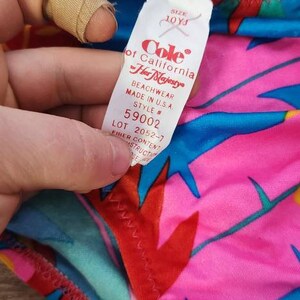 Pode incluir: Roupa de praia vintage Cole of California Her Majesty. O fato de banho apresenta um padr&atilde;o floral vibrante em rosa, azul e vermelho. A etiqueta diz "Made in U.S.A." e indica o tamanho 10YJ.