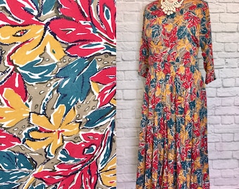 May include: A long, flowing dress with a floral print in shades of red, yellow, and green. The dress has a gathered skirt and 3/4 sleeves.